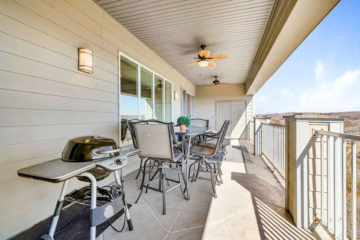 A private deck featuring comfortable outdoor seating and an electric grill, set against the backdrop of a shimmering lake. The space is designed for al fresco dining and relaxation, perfect for enjoying morning coffee or evening cocktails while soaking in the views.